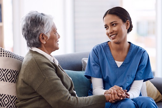 A caring nurse taking care of an elderly patient at home.